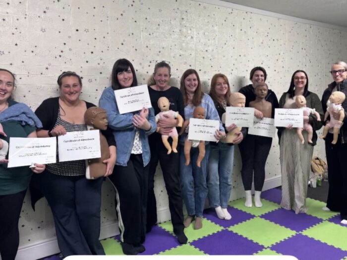 A group of learners holding their certificates after a paediatric first aid course