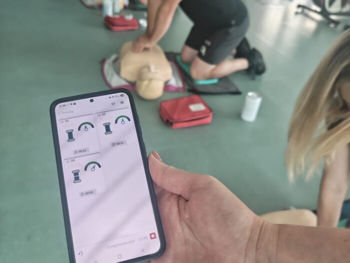 Practising CPR while following emergency call guidance on a mobile phone