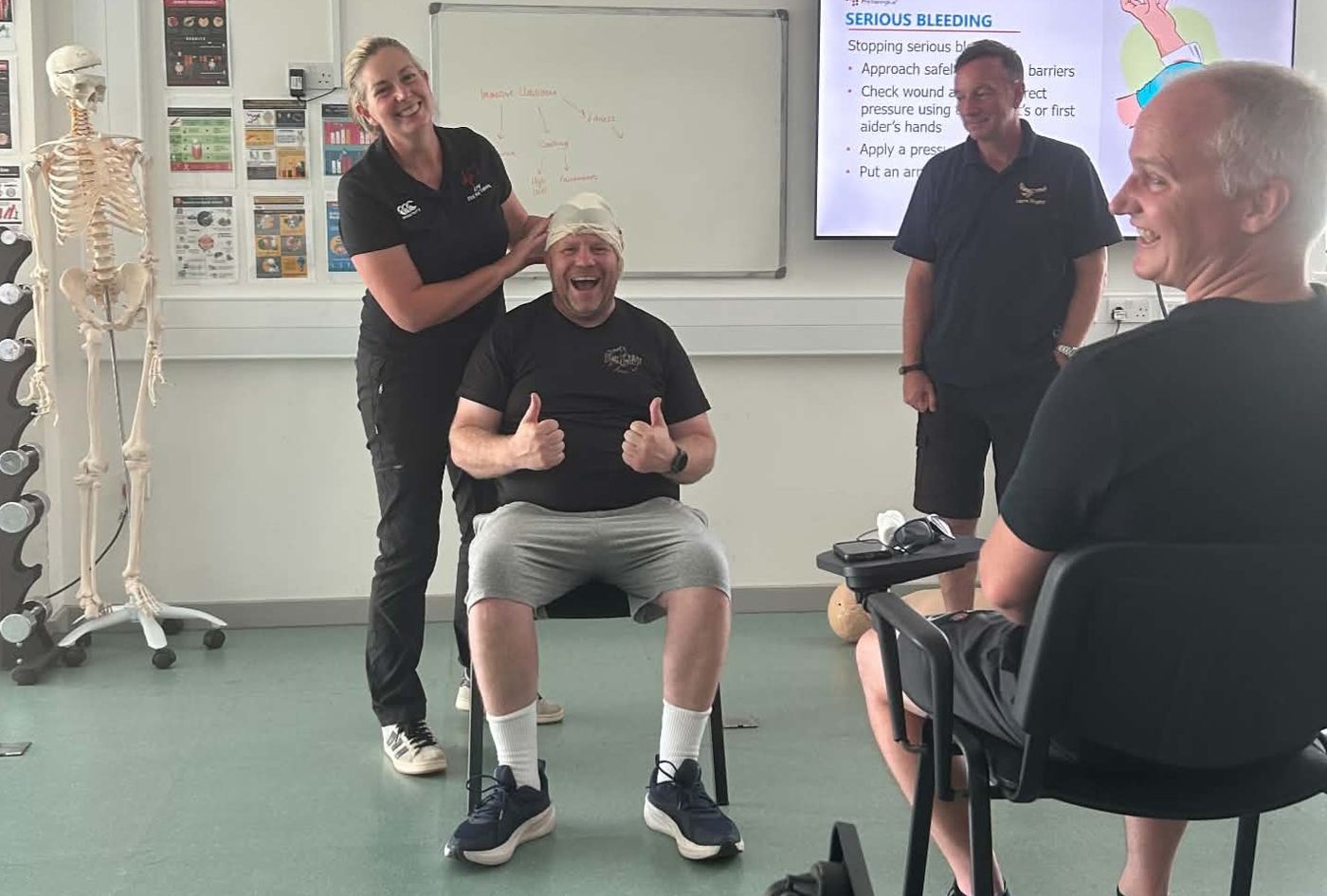 A learner having a head dressing applied during a practical first aid exercise